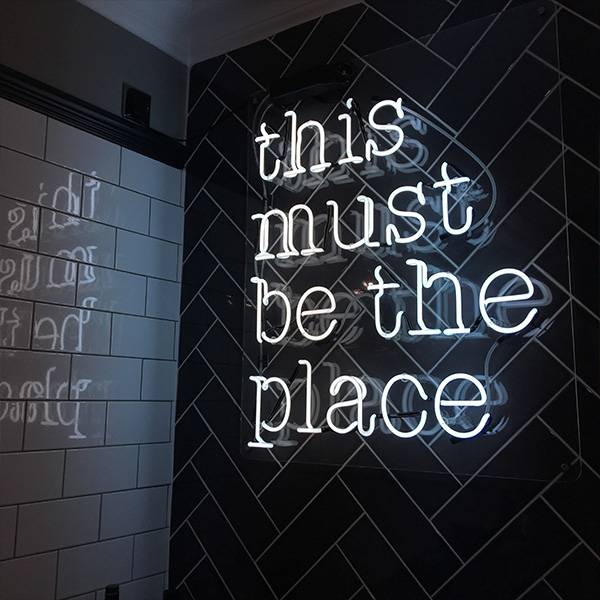 Neon light sign white this must be the place